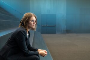 Businessfoto Indoor, Frau sitzt auf Stufen