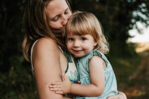 Familienfoto, Mutter kuschelt mit Tochter