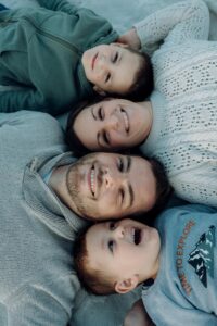 Familie liegt Kopf an Kopf versetzt